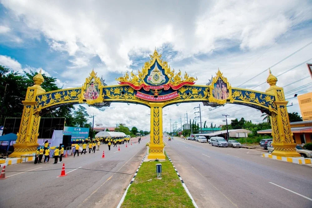 ภาพตัวอย่างลักษณะงาน: ซุ้มเฉลิมพระเกียรติลายไทยสีทองและน้ำเงินแบบสามเสา คร่อมถนนสองฝั่ง