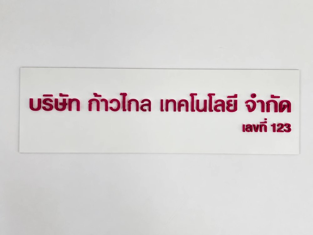 ภาพตัวอย่างลักษณะงาน: ตัวอักษรไทยสีบานเย็นนูนบนแผ่นพื้นสีขาว ชื่อบริษัทและเลขที่
